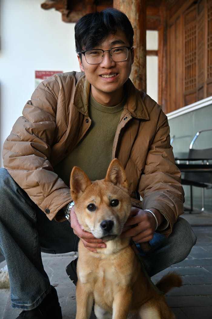 Smiling man with dog outdoors, showcasing friendship and warmth.